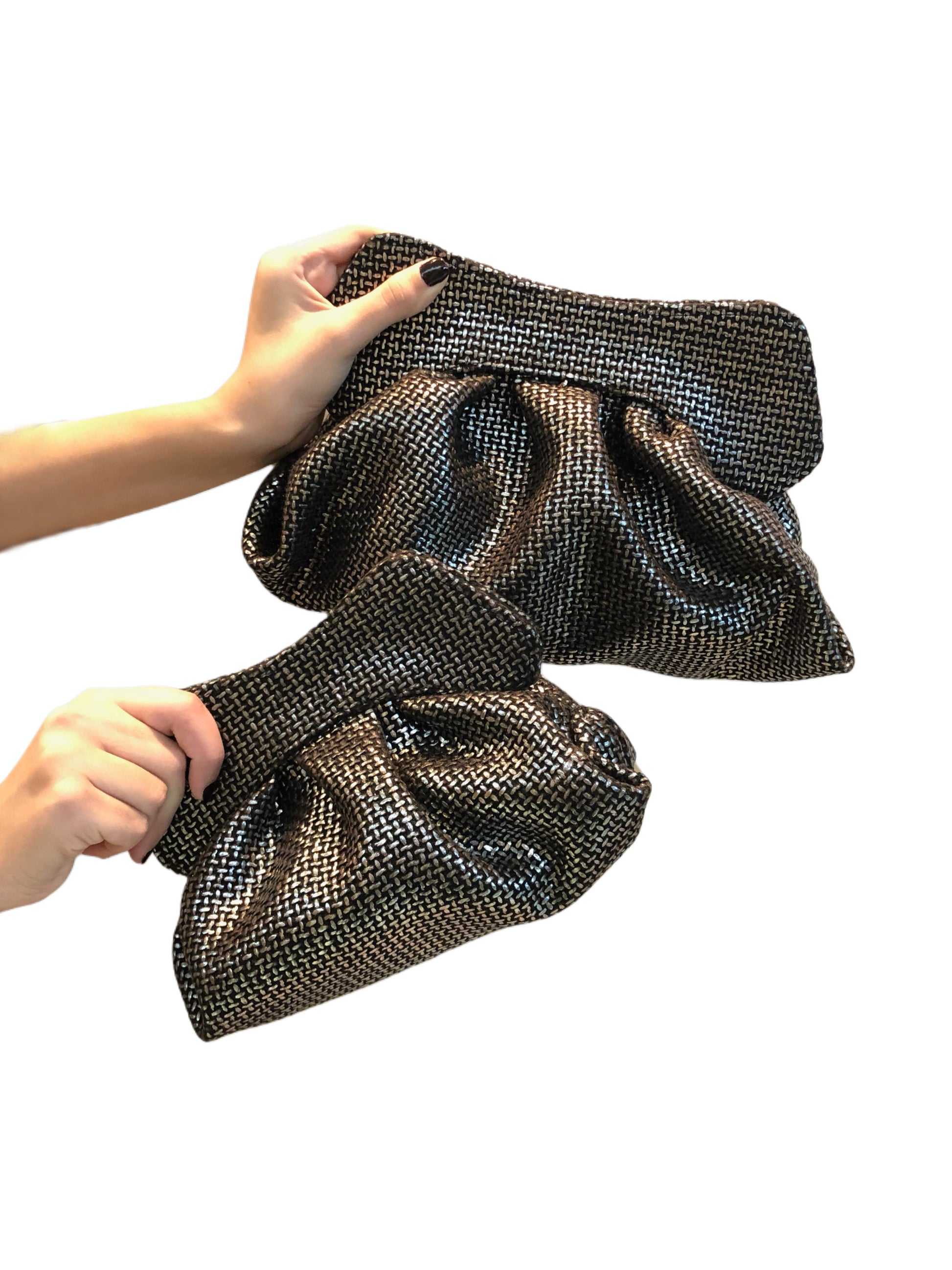 Black silver canvas bag held by a person on a white background